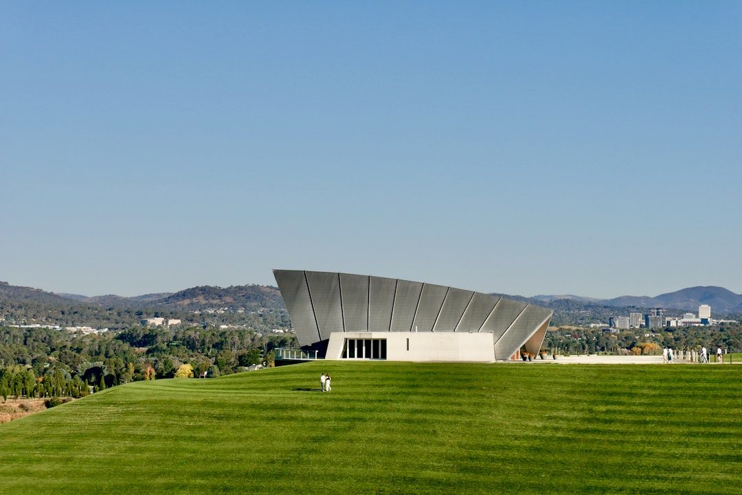 gray-building-on-green-grass-field-under-blue-sky-during-daytime-ddvukbknh0m
